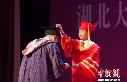 图为，必赢中国官方网站校长赵凌云为毕业生拨穗正冠 向正鹏 摄